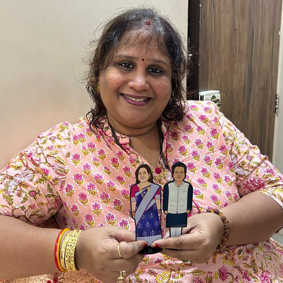 Woman holding a photograph of herself and her husband in a floral dress.